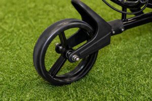 Golf cart wheel on green grass.