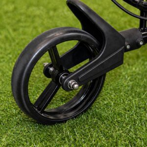 Golf cart wheel on green grass.