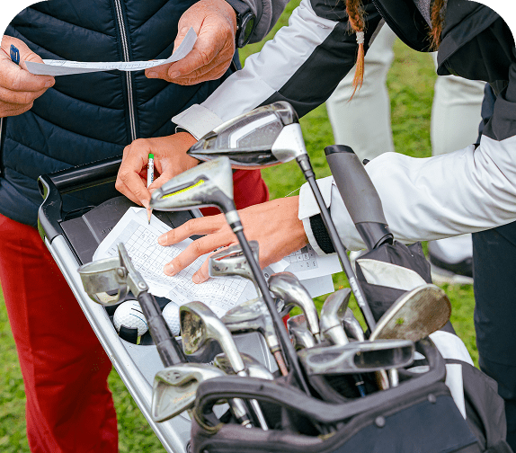 Hands examining golf scores by club bag