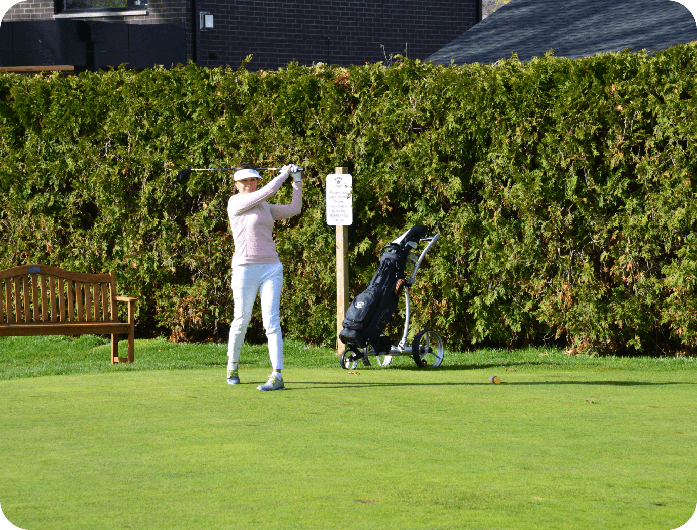 Golfer swinging on a sunny course.